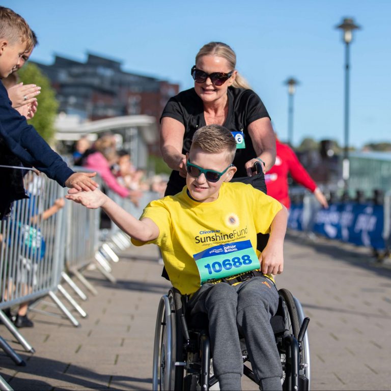 boy giving high fives towards finish line