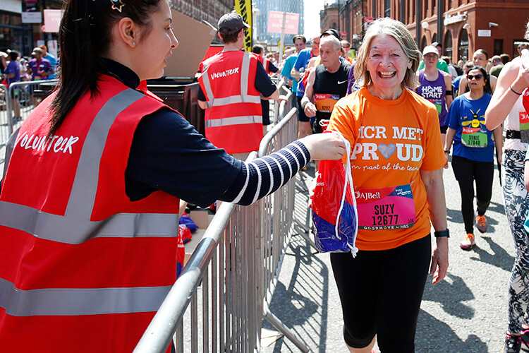 Smiling runner collecting finisher pack with no t-shirt