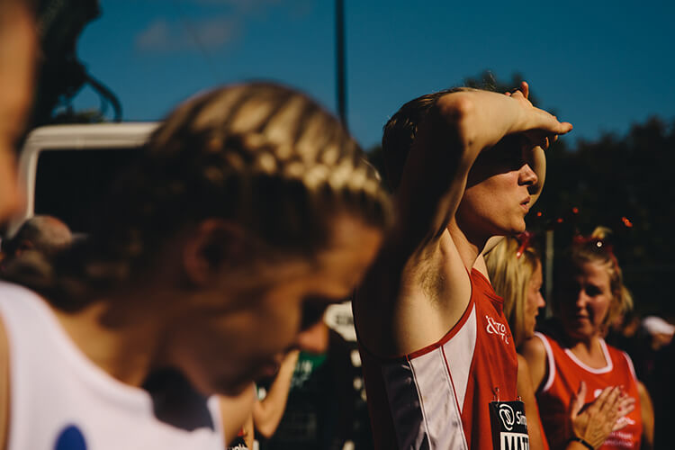 Runner shielding eyes from the sun waiting on the start line.