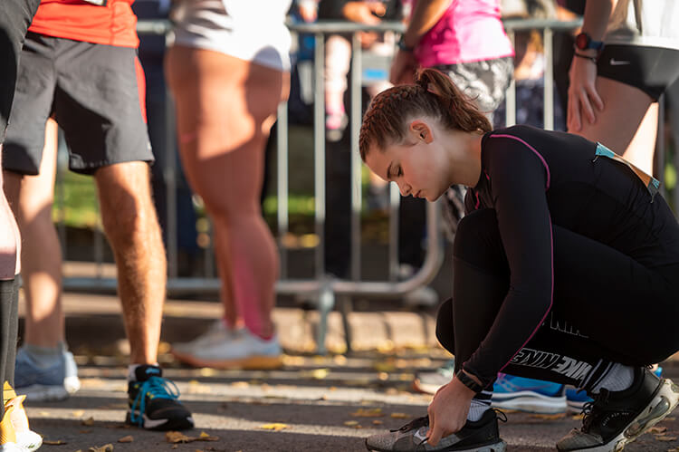 Runner lacing up trainers on the start line